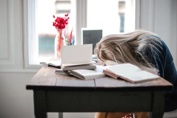 A girl asleep on a study table while preparing for USMLE